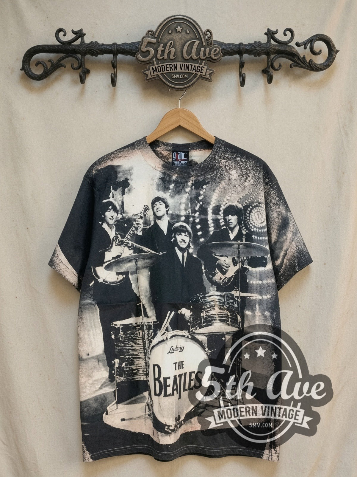 The Beatles Live Stage Ludwig Drum all-over-print vintage band t-shirt in black, front view on a display rack