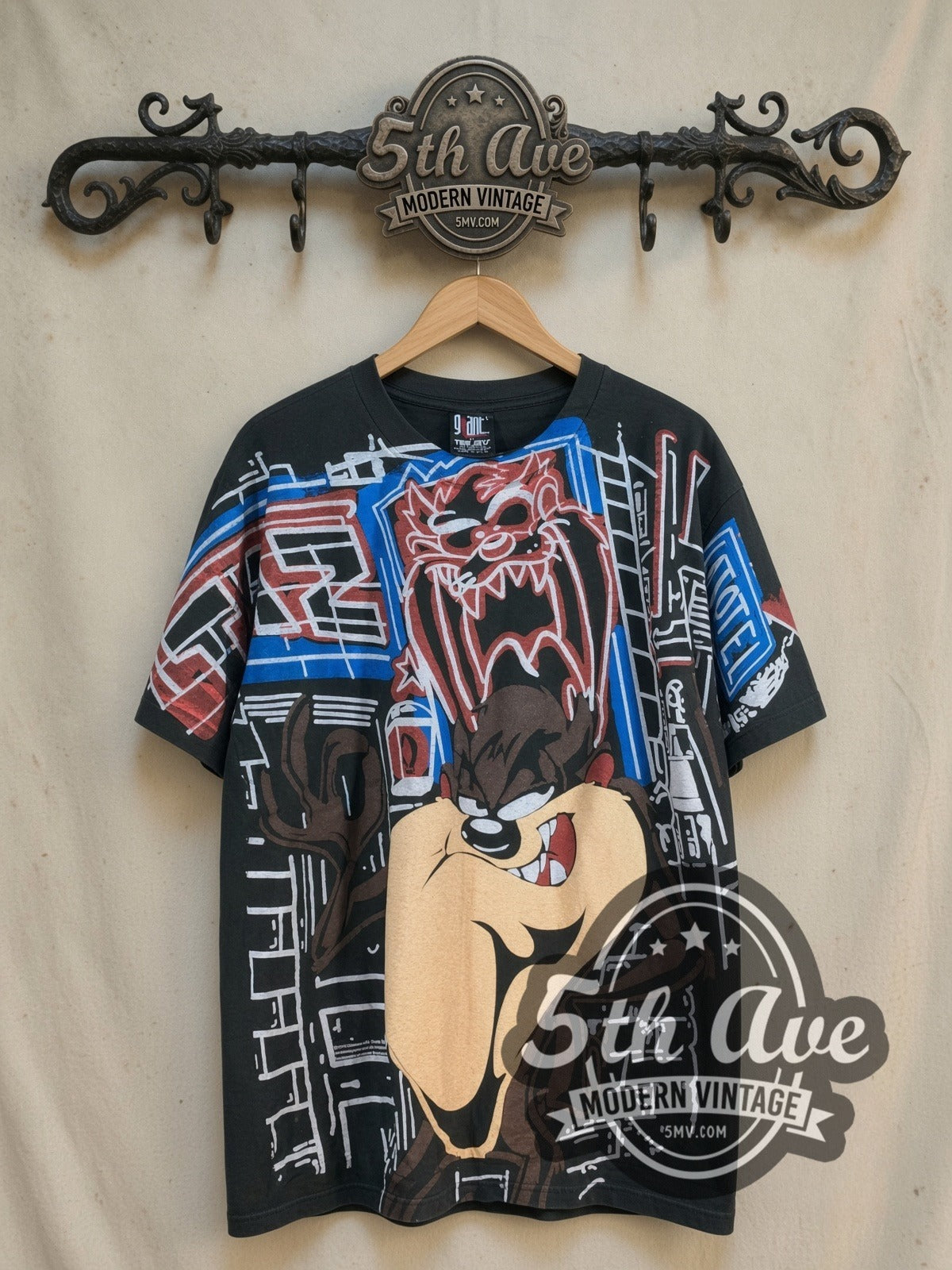 Looney Tunes Taz-Mania Limited Edition all-over-print vintage cartoon tee, front view on a display rack