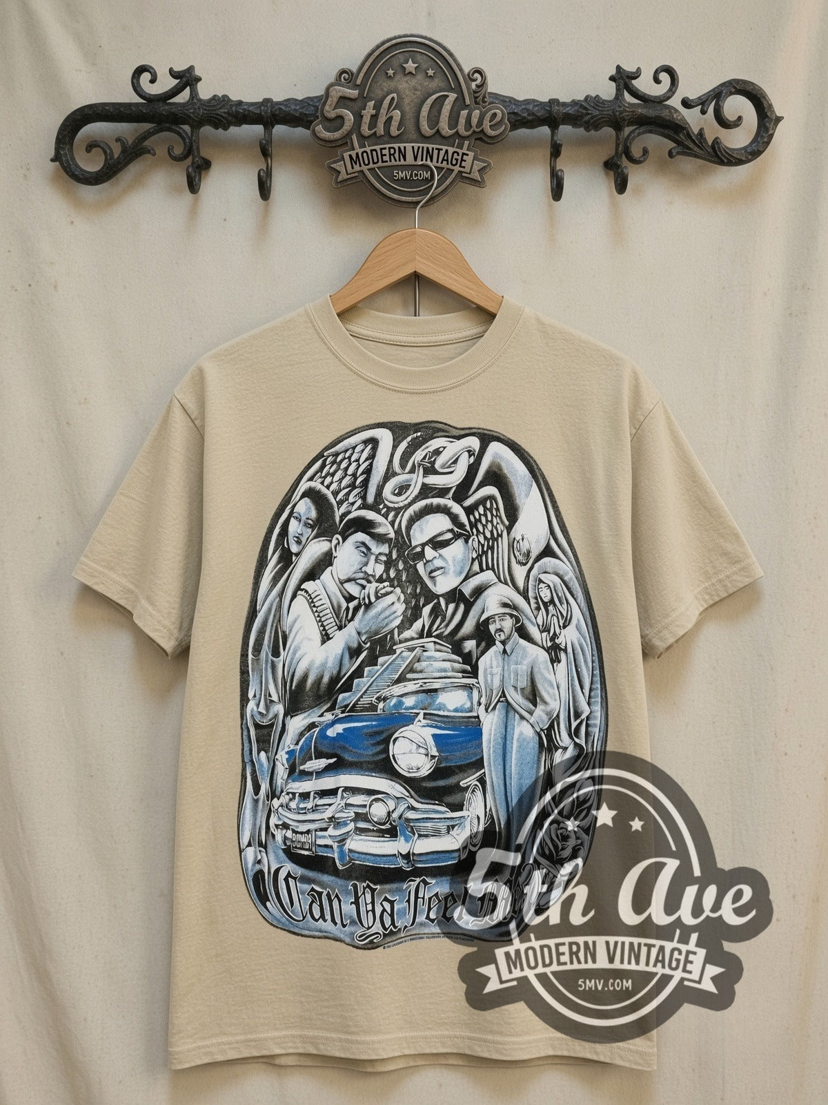 Rollin Hard Can Ya Feel Me Lowrider vintage graphic tee in sand, front view on a display rack
