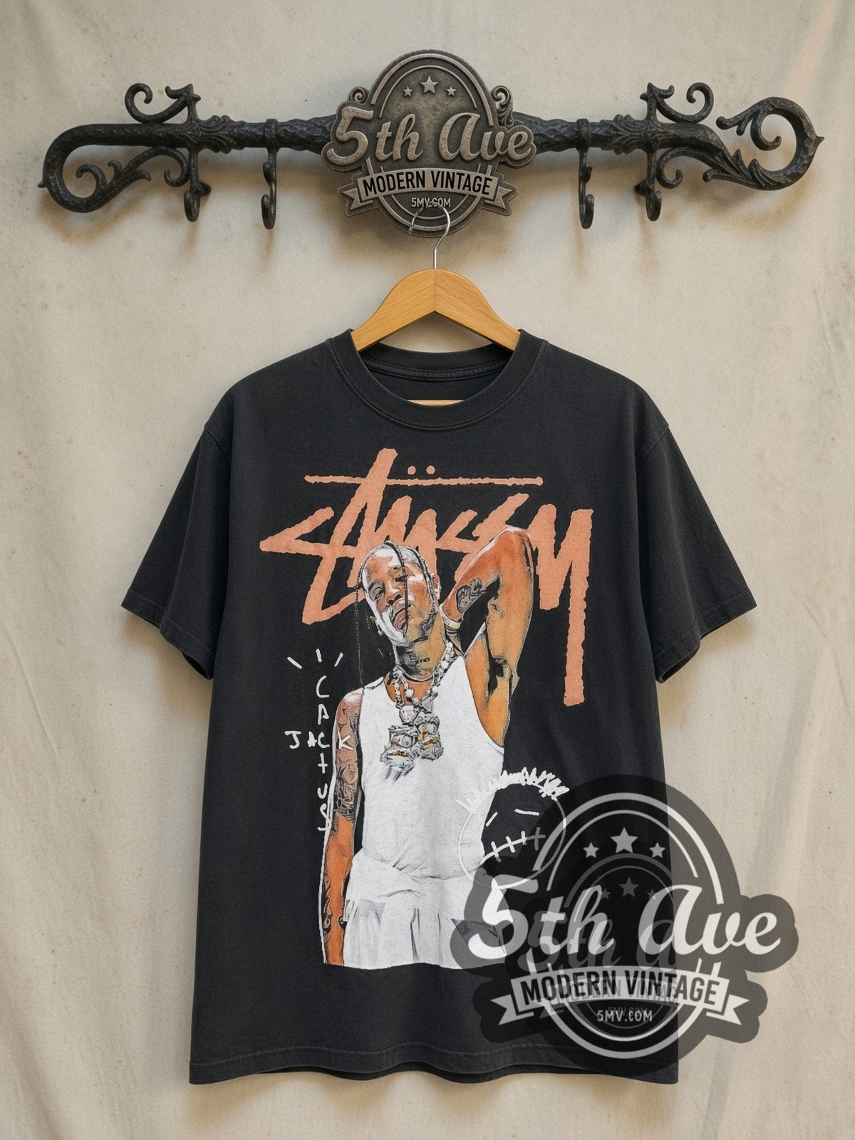 Travis Scott x Stüssy Astroworld graphic tee in black, front view on a display rack