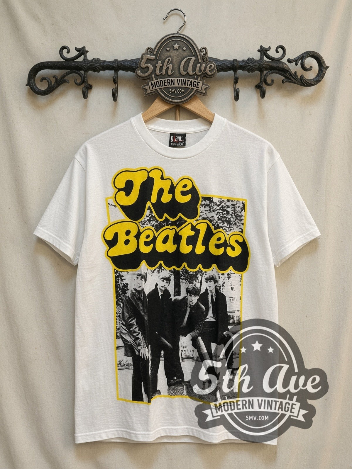 The Beatles Yellow Bubble Font Early Photo vintage band t-shirt, front view on a display rack