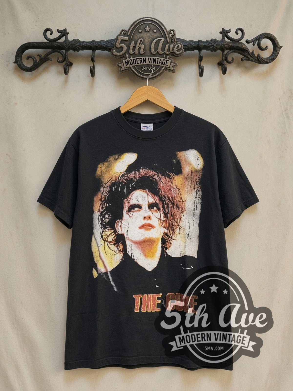 The Cure Greatest Hits vintage band t-shirt in black, front view on a display rack
