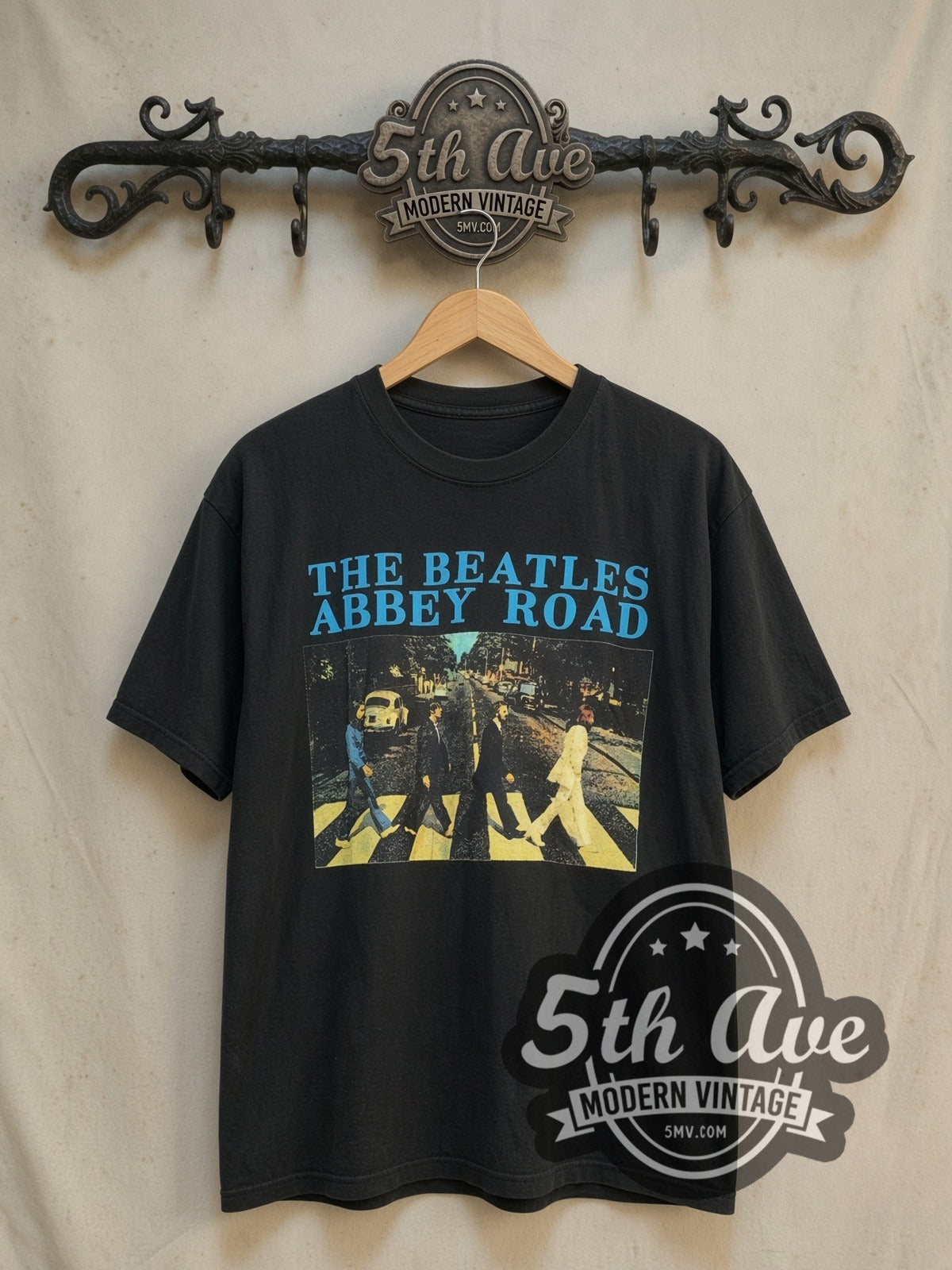 The Beatles Abbey Road Crossing Cyan Logo vintage band t-shirt, front view on a display rack