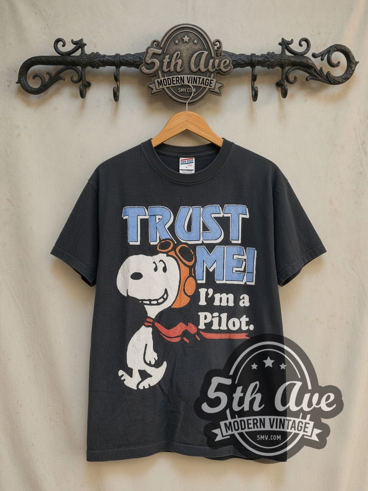 Peanuts Snoopy Trust Me I'm a Pilot vintage cartoon tee in black, front view on a display rack