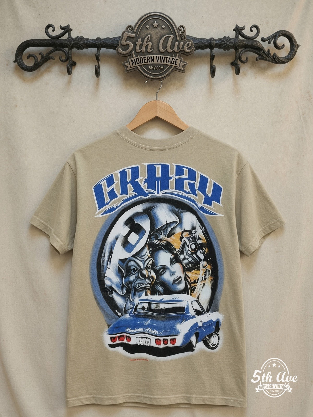 Rollin Hard Crazy Lowrider graphic tee in sand, front view on a display rack