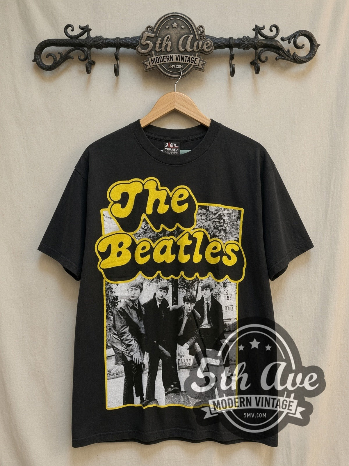 The Beatles Yellow Border Early Suits Photo vintage band t-shirt, front view on a display rack