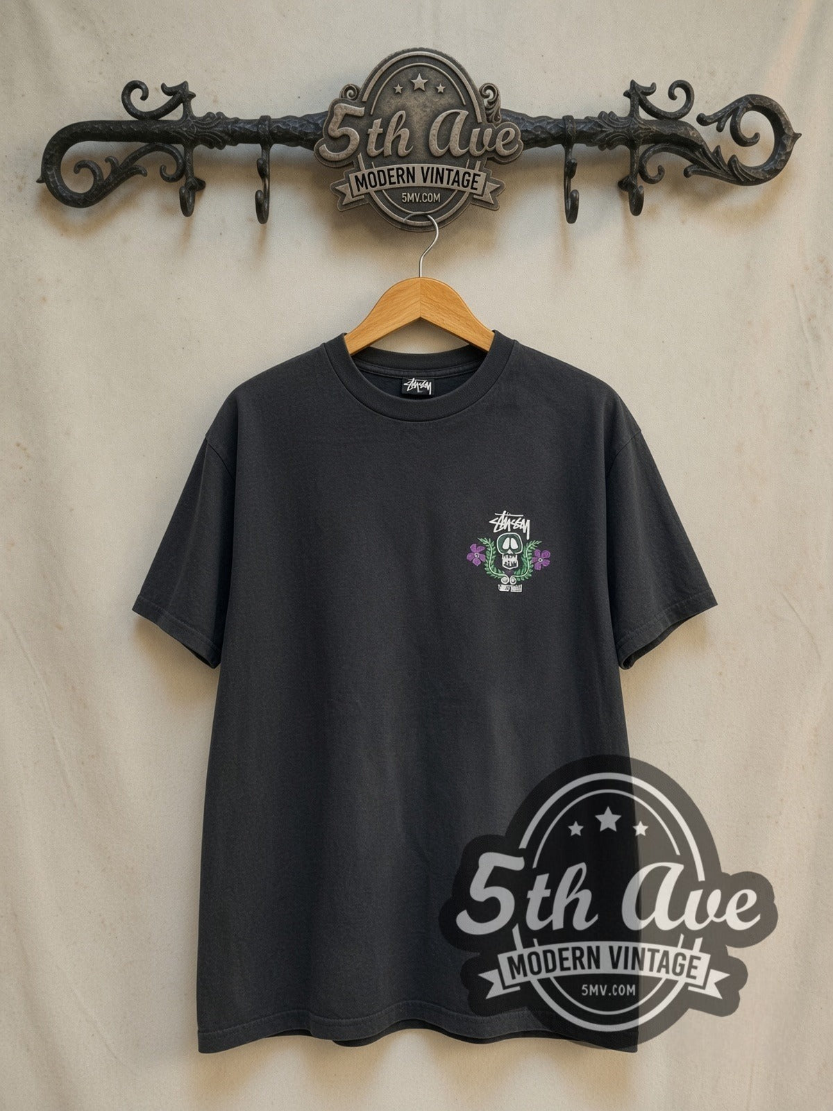 Stussy World Tribe Skull Crest vintage graphic tee in black, front view on the 5MV rack