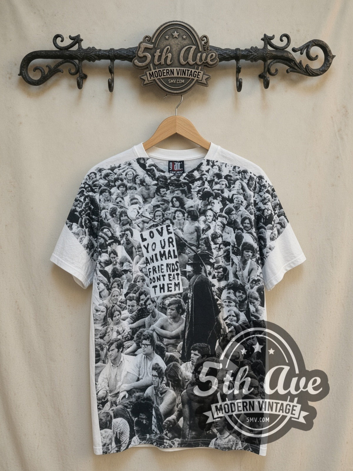 Woodstock Love Your Animal Friends, Don't Eat Them all-over-print vintage graphic tee, front view on a display rack