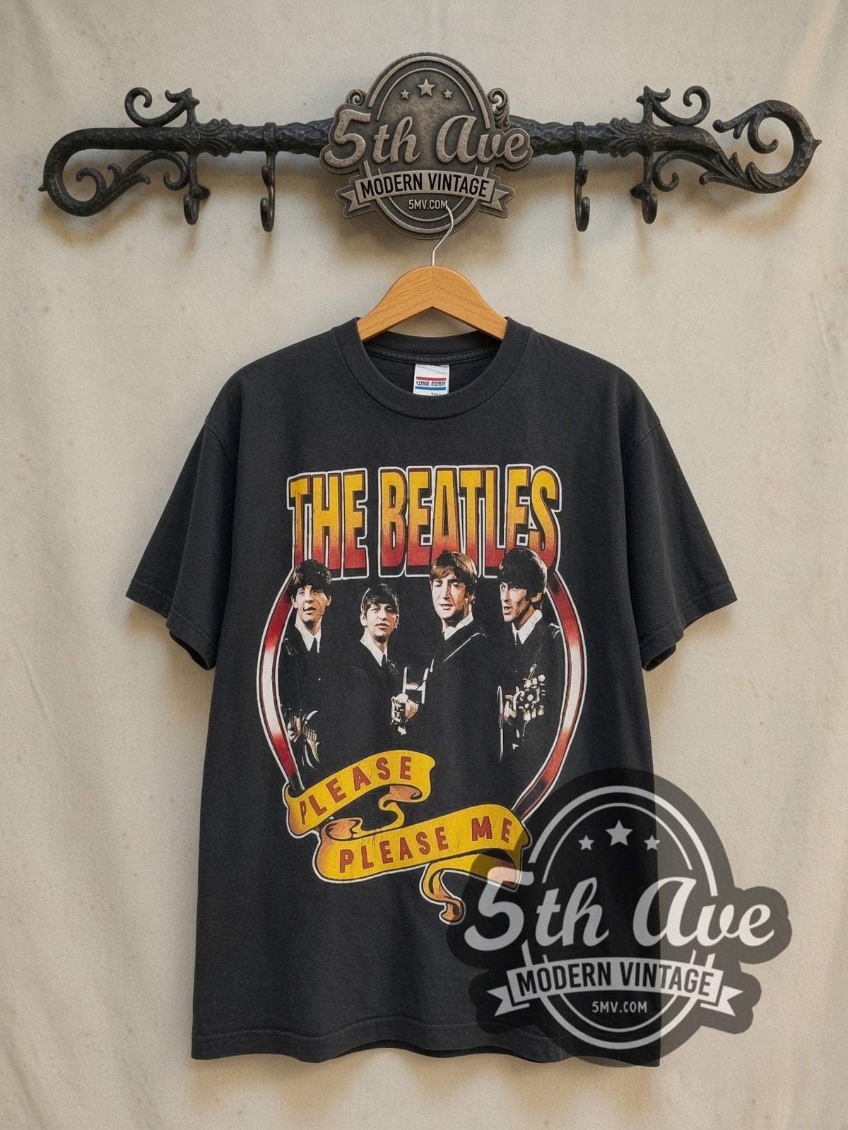 The Beatles Please Please Me 1963 vintage band t-shirt in black, front view on a display rack