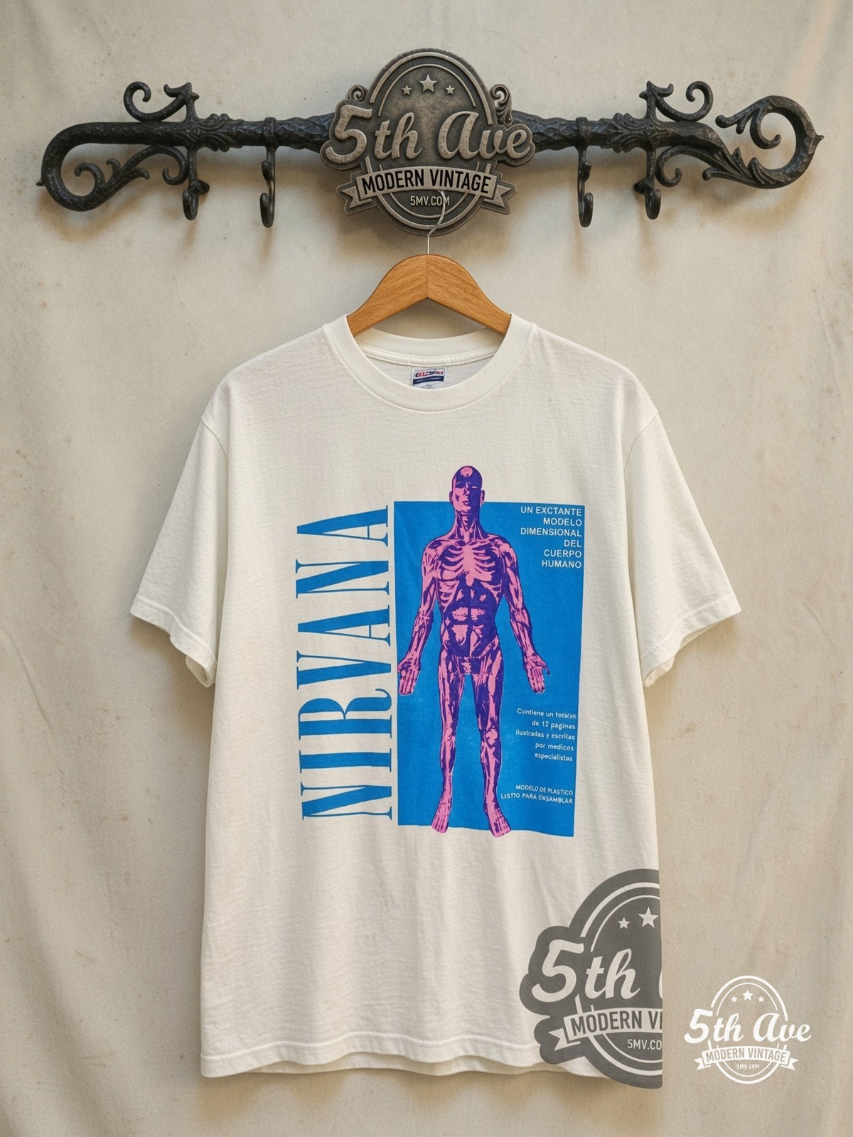 Nirvana – Sliver Spanish Text Anatomical Figure – Vintage Band T-Shirt — front on locked cream ornate 5th Ave rack