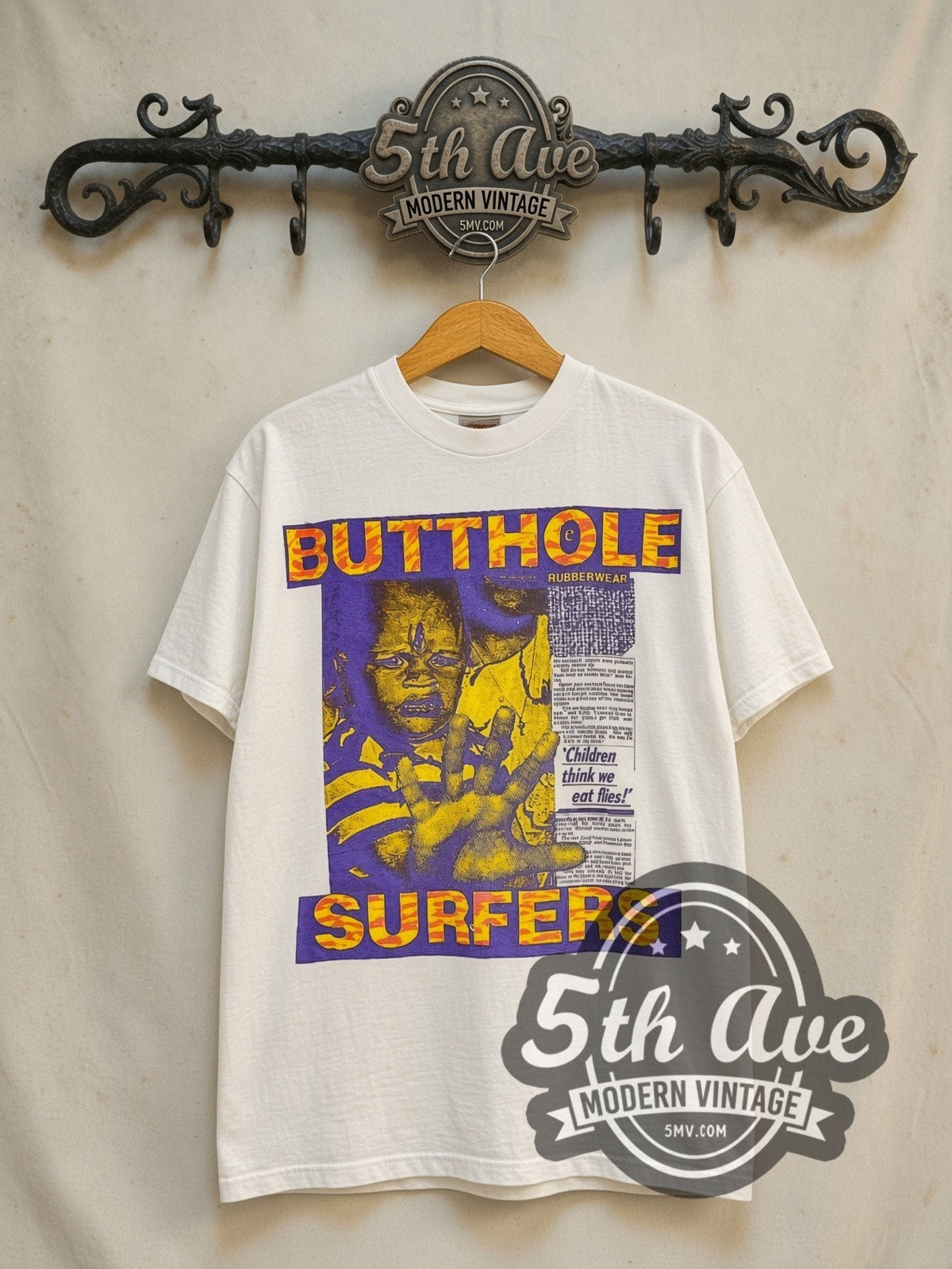 Butthole Surfers Children Think We Eat Flies vintage band t-shirt in white, front view on a display rack