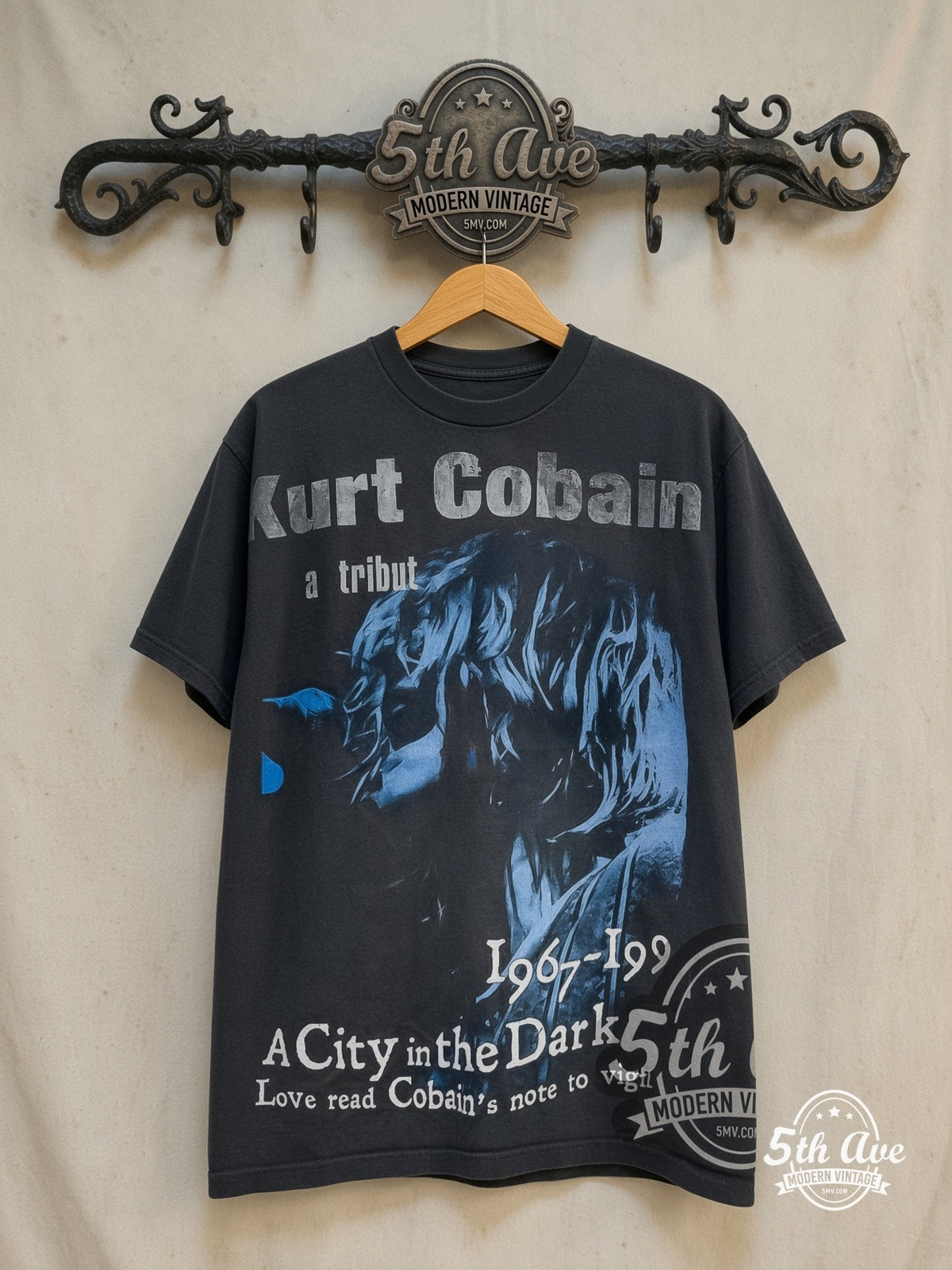 Nirvana – A City in the Dark 1967-1994 – All Over Print – Vintage Band T-Shirt — front on locked cream ornate 5th Ave rack