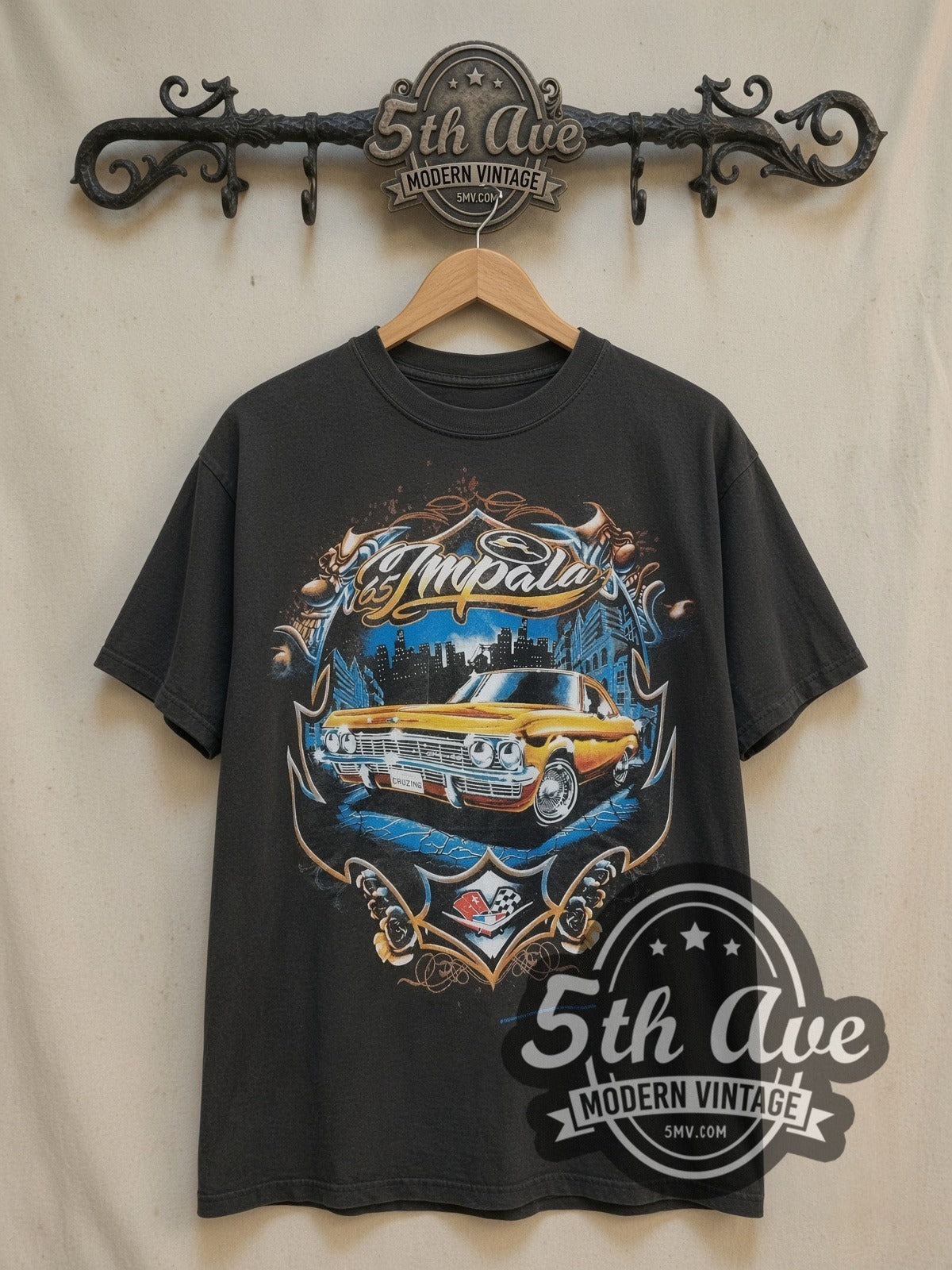 Rollin Hard '65 Chevy Impala Lowrider vintage graphic tee, front view on a display rack