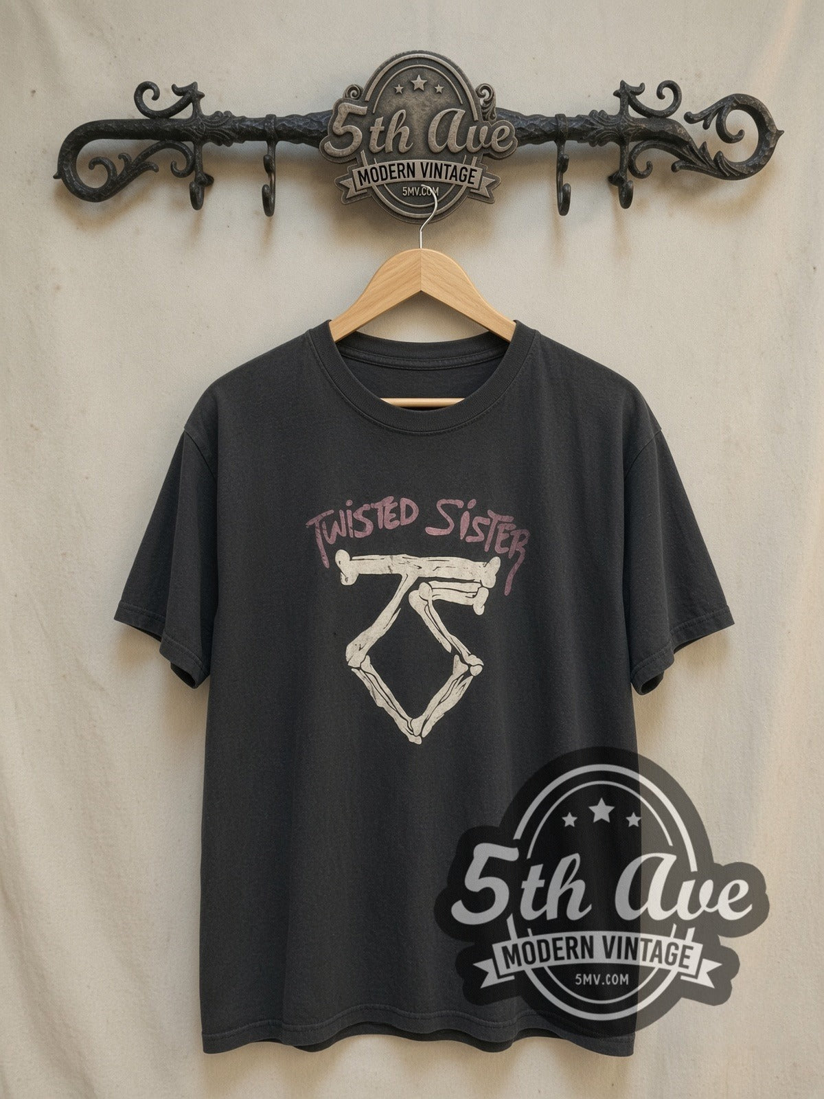 Twisted Sister Bone TS Logo Pink Band Name vintage band t-shirt, front view on a display rack