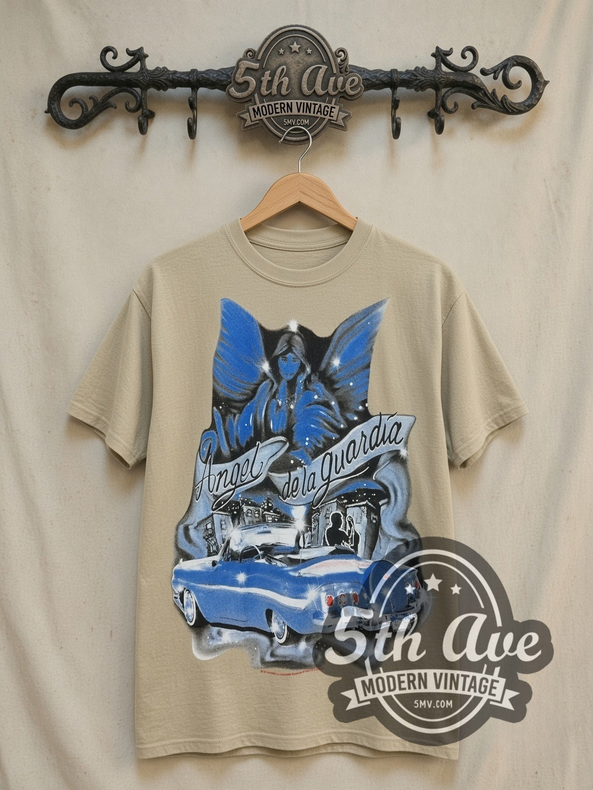 Rollin Hard Angel de la Guardia Lowrider vintage graphic tee in sand, front view on a display rack