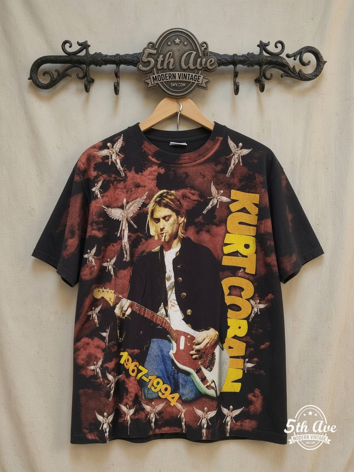 Nirvana – Nirvana Vintage Soft Cotton Band T-Shirt – All Over Print – Vintage Band T-Shirt — front on locked cream ornate 5th Ave rack