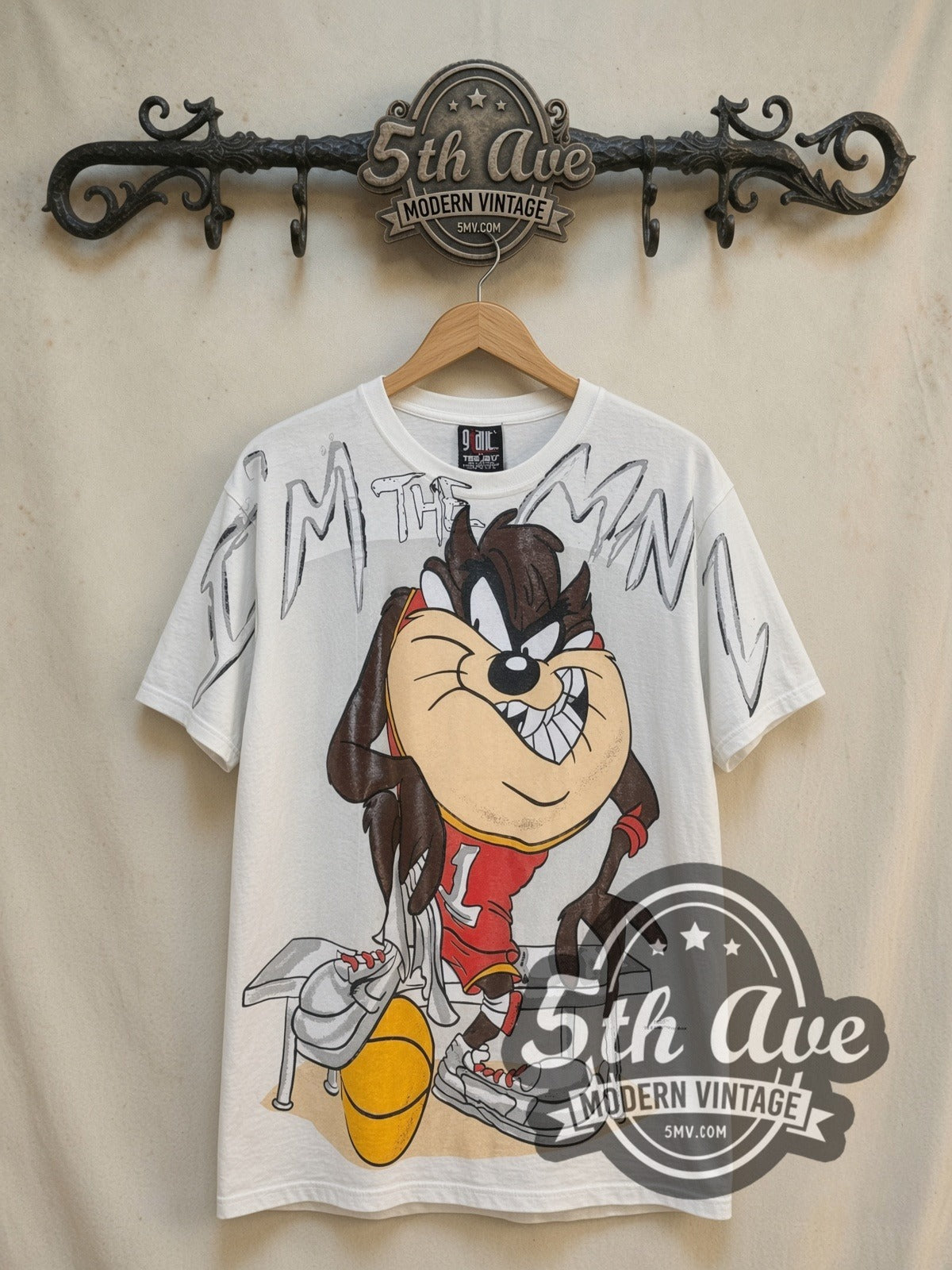 Looney Tunes Taz-Mania Bold Print all-over-print vintage cartoon tee, front view on a display rack