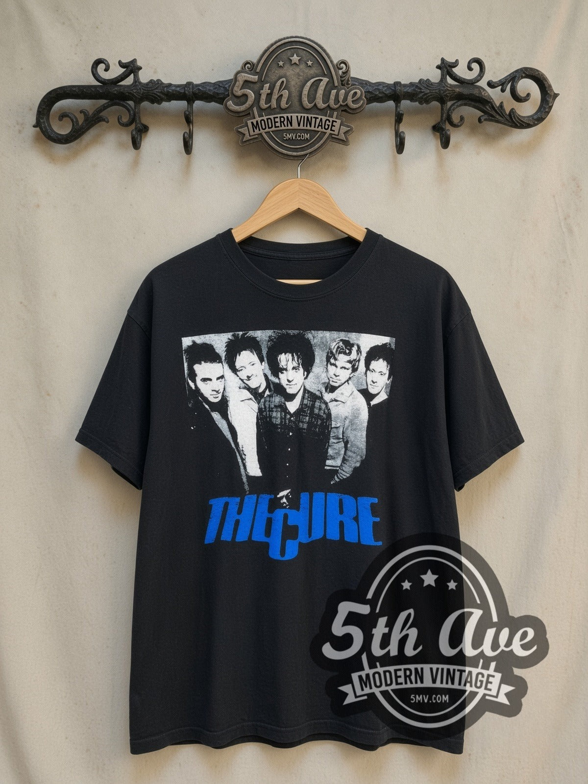The Cure Five Member Photo Blue Logo vintage band t-shirt, front view on a display rack