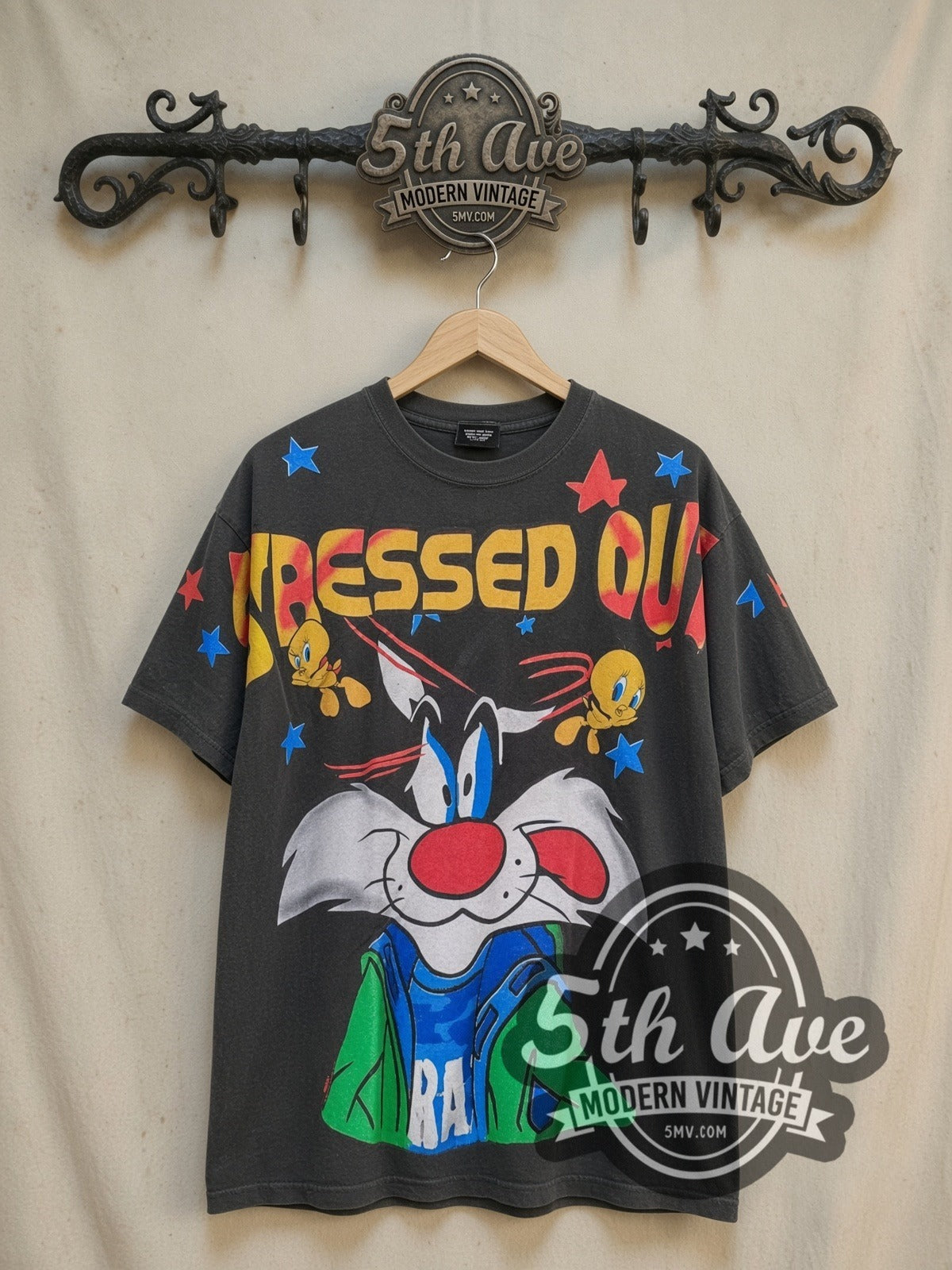 Looney Tunes Sylvester and Tweety all-over-print vintage cartoon tee, front view on a display rack