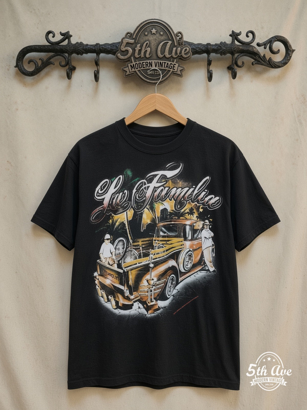 Rollin Hard For Familia Lowrider graphic tee, front view on a display rack