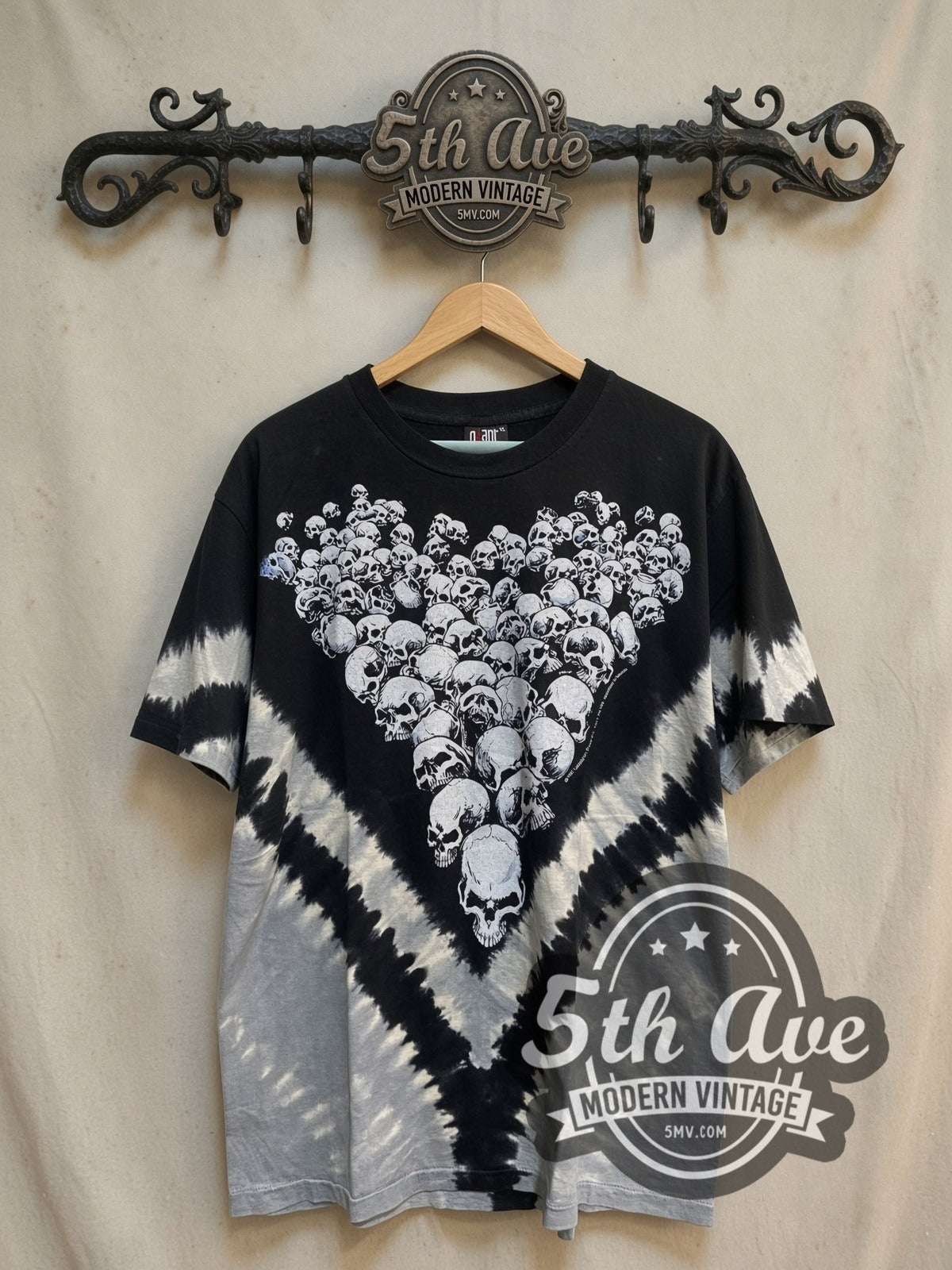 Boneyard Skulls Tie-Dye Skull Pile all-over-print vintage graphic tee, front view on a display rack
