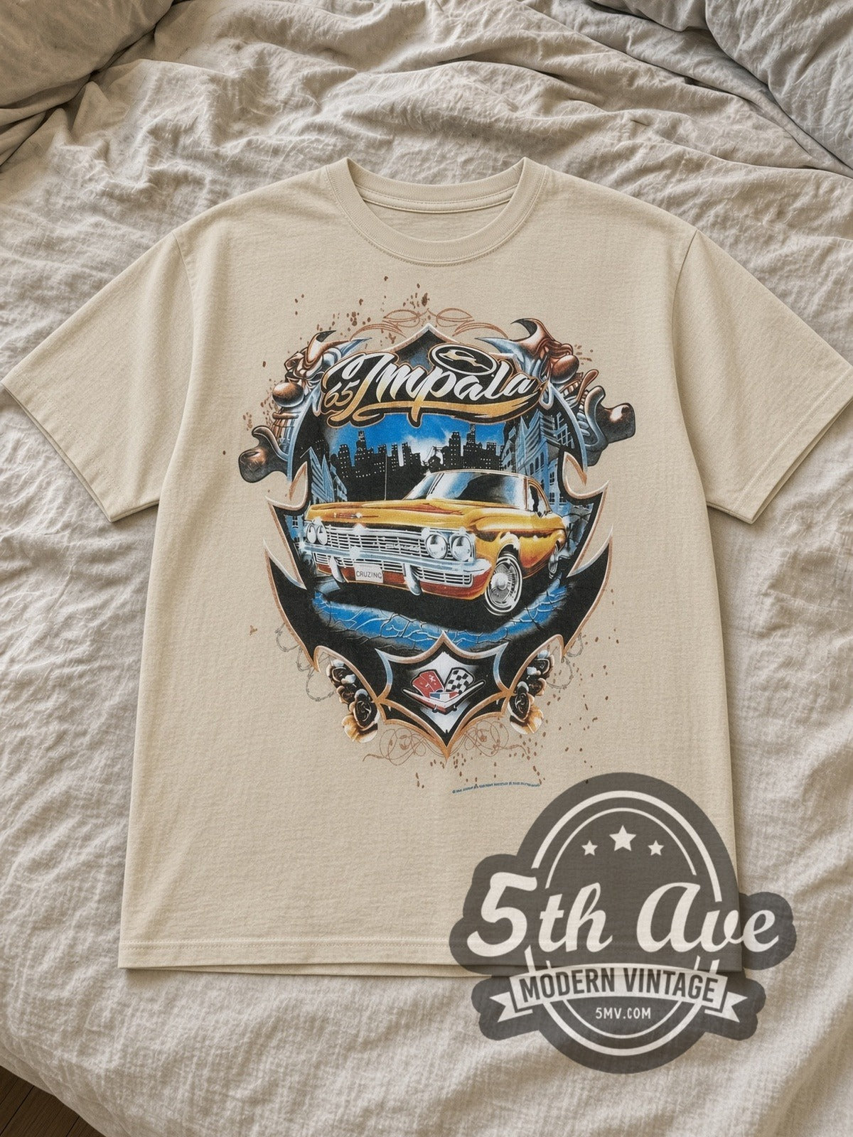 Sand Rollin Hard Golden Impala Lowrider Vintage Graphic T-Shirt laid flat on a linen bed