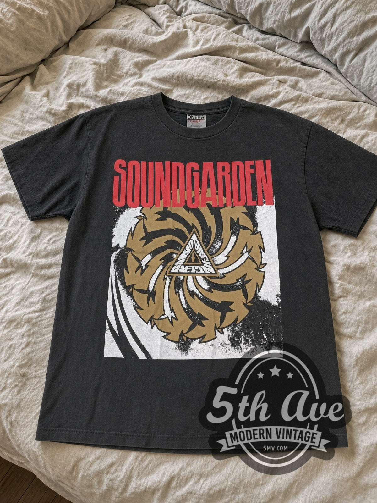 Faded black Soundgarden Badmotorfinger saw blade tee laid flat on linen bed