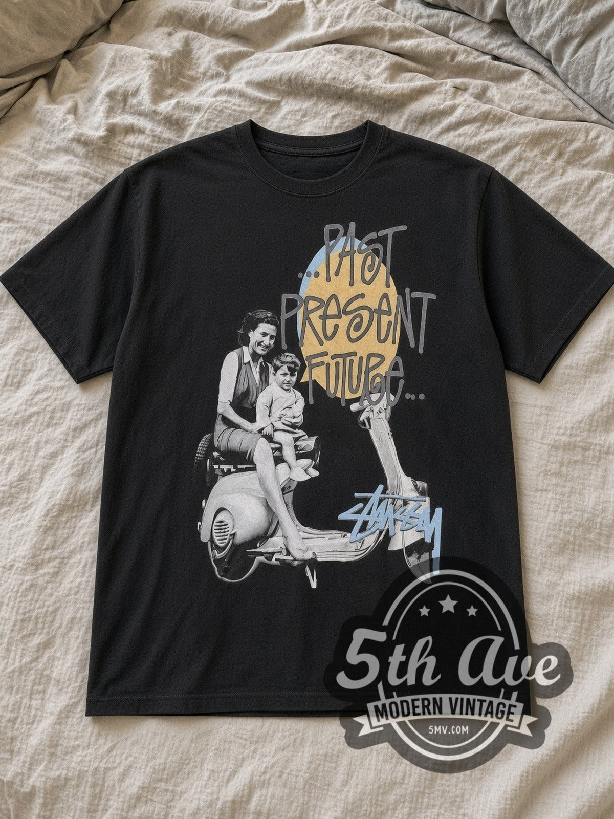 Black Stussy Past Present Future Vintage Graphic T-Shirt laid flat on a linen bed