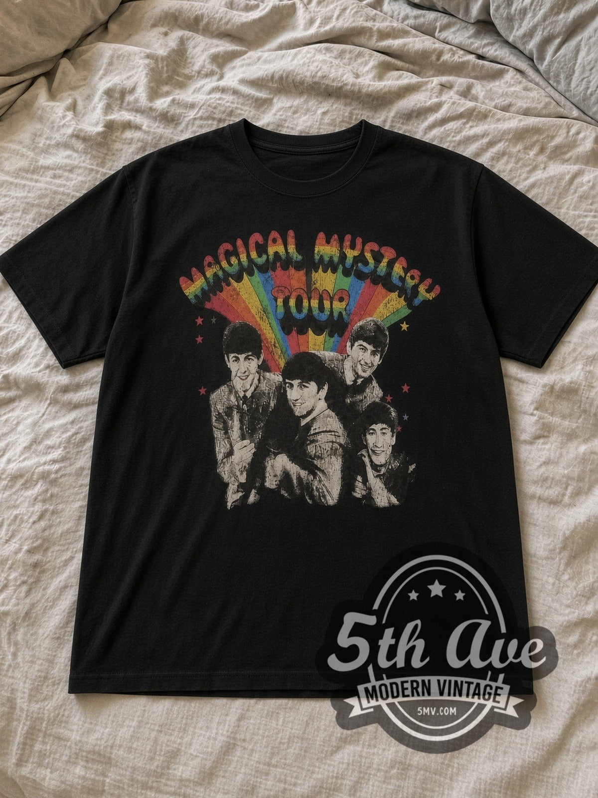 Black The Beatles Magical Mystery Tour Rainbow Vintage Band T-Shirt laid flat on a linen bed