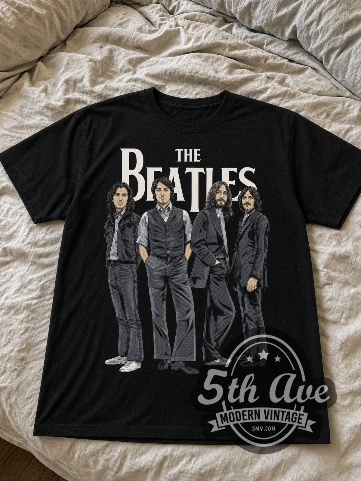 The Beatles group portrait black graphic tee laid flat on linen bed