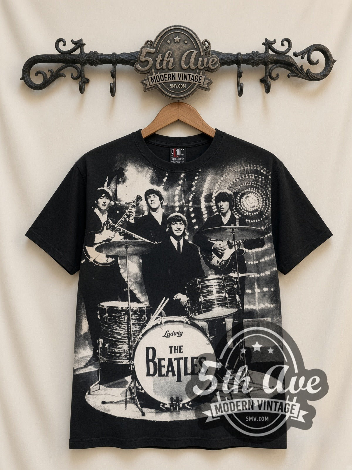 The Beatles Photo Collage Drums all-over-print vintage band t-shirt in black, front view on a display rack