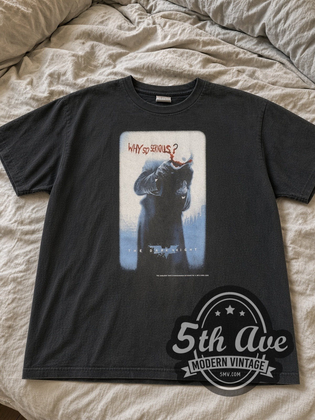 Faded black Dark Knight Joker Why So Serious tee laid flat on linen bed