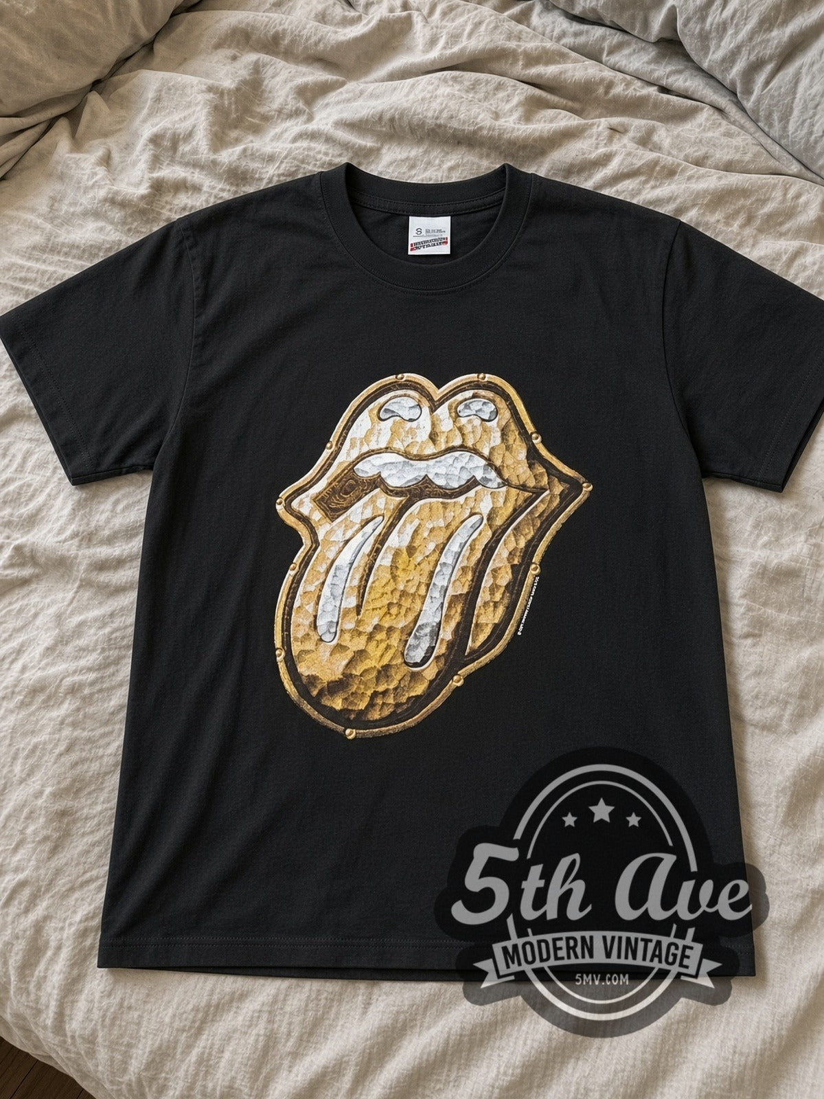The Rolling Stones Bridges to Babylon Gold Tongue band t-shirt in black laid flat on a bed, front artwork