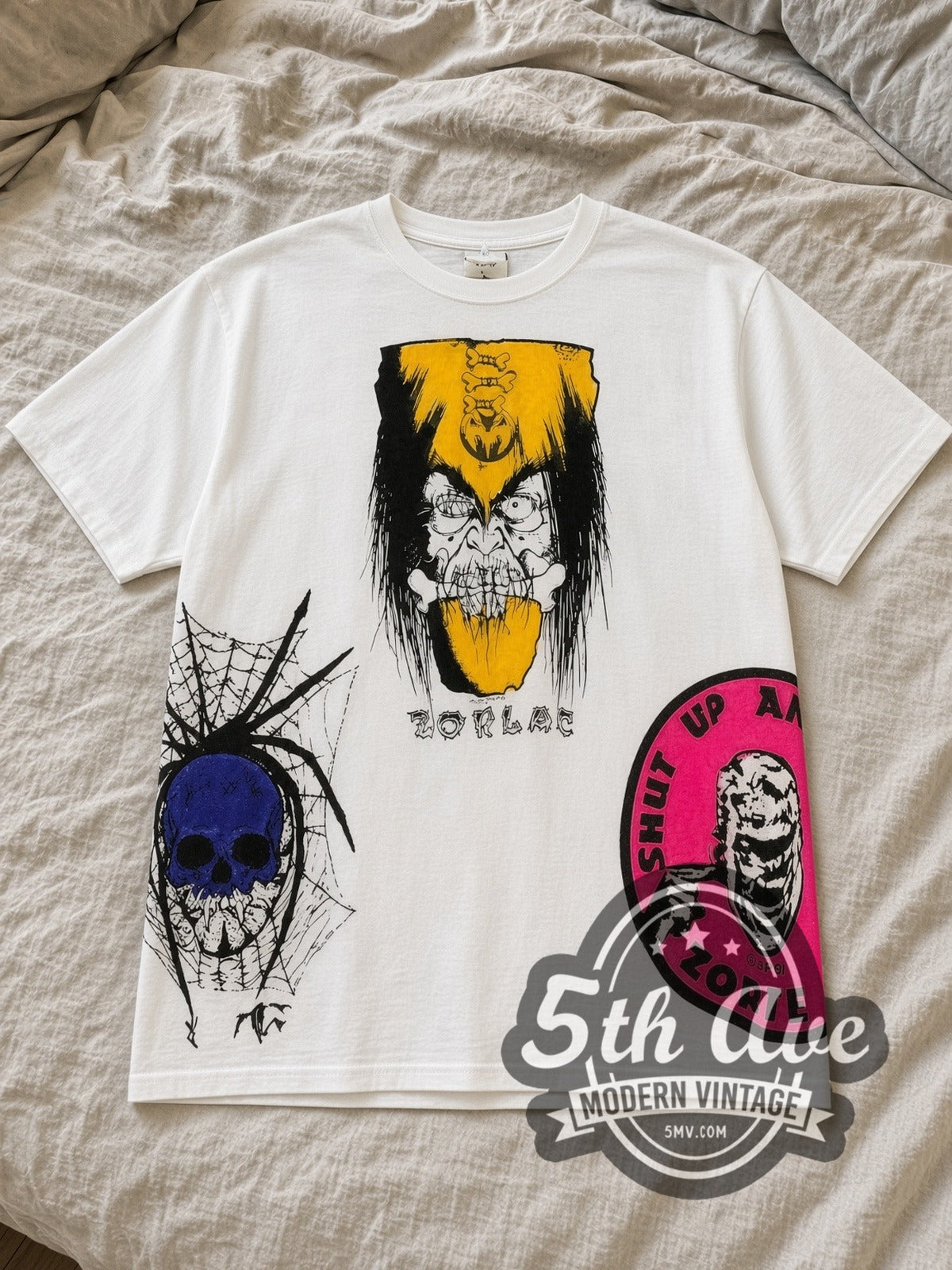 White Zorlac Skateboards Shut Up and Skate All Over Print Vintage Graphic T-Shirt laid flat on a linen bed