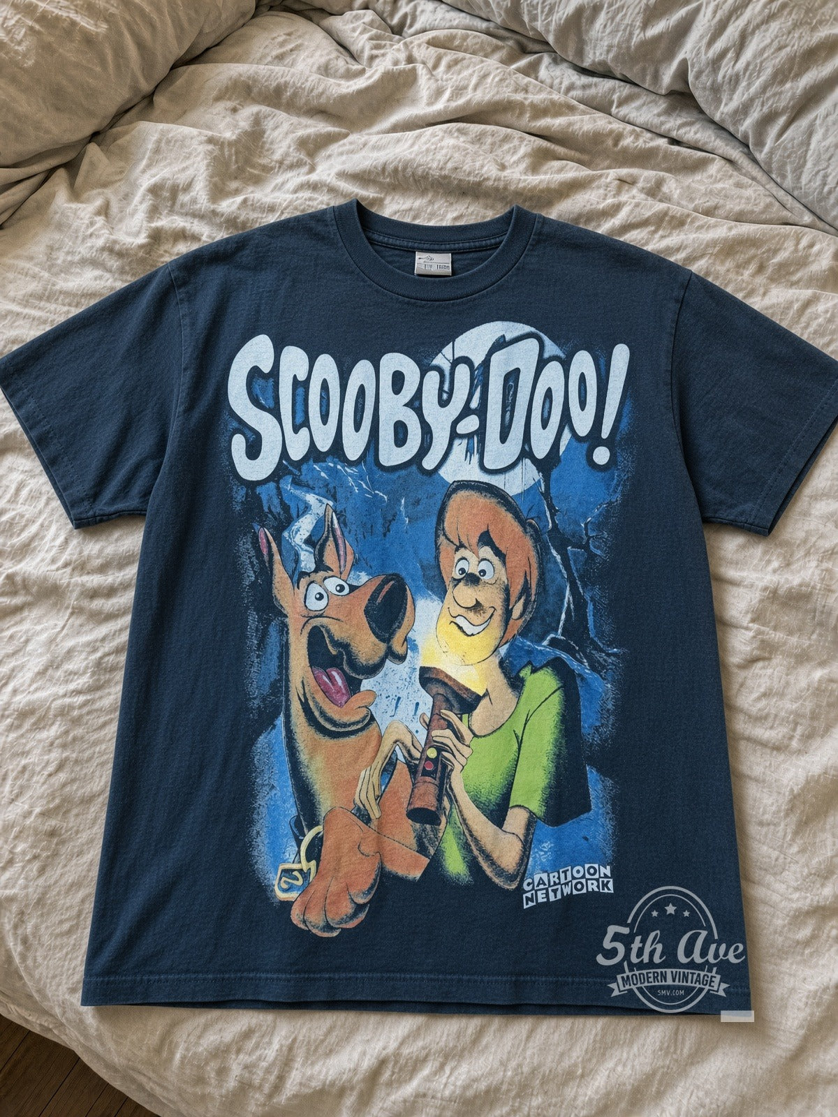 Scooby-Doo shirt front laid flat on bed, faded navy tee with Scooby and Shaggy flashlight print