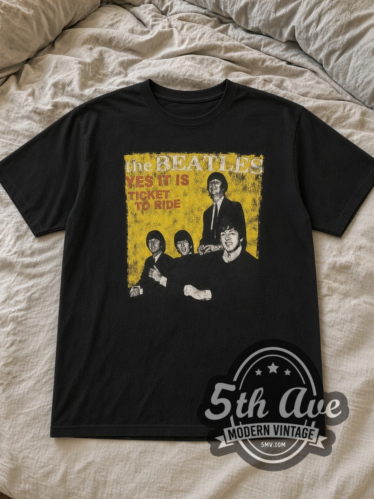 Black The Beatles TICKET TO RIDE Vintage Band T-Shirt laid flat on a linen bed