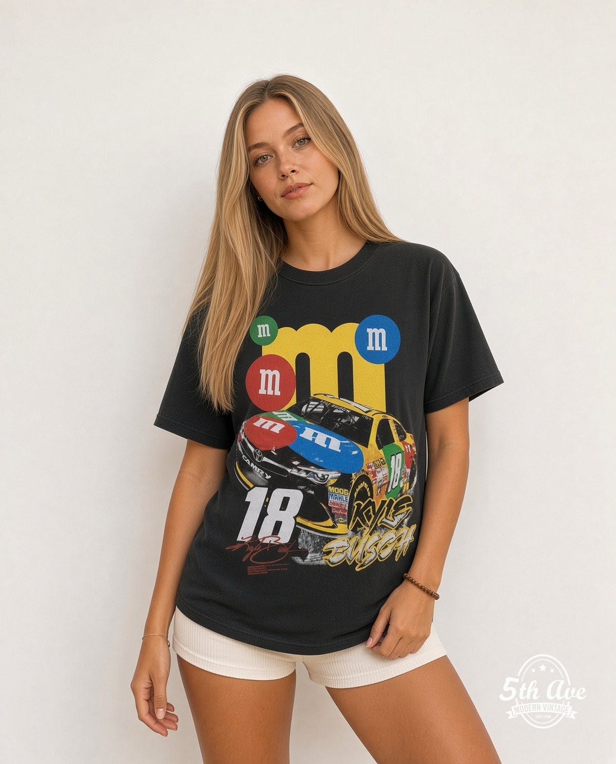 Model wearing the NASCAR Kyle Busch #18 M&M's Characters all-over-print vintage graphic t-shirt in black