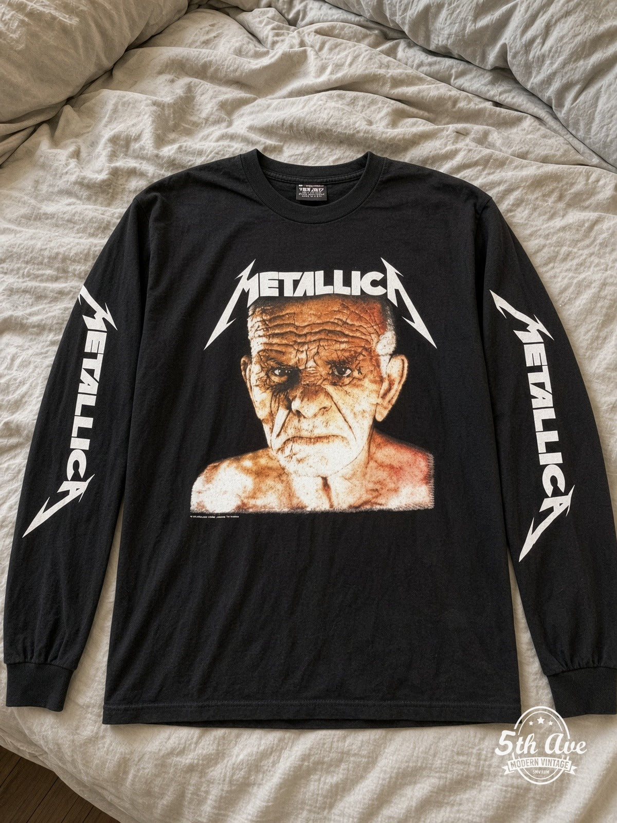 ETS LS 24 Metallica Old Man Face long sleeve vintage tee laid on a bed