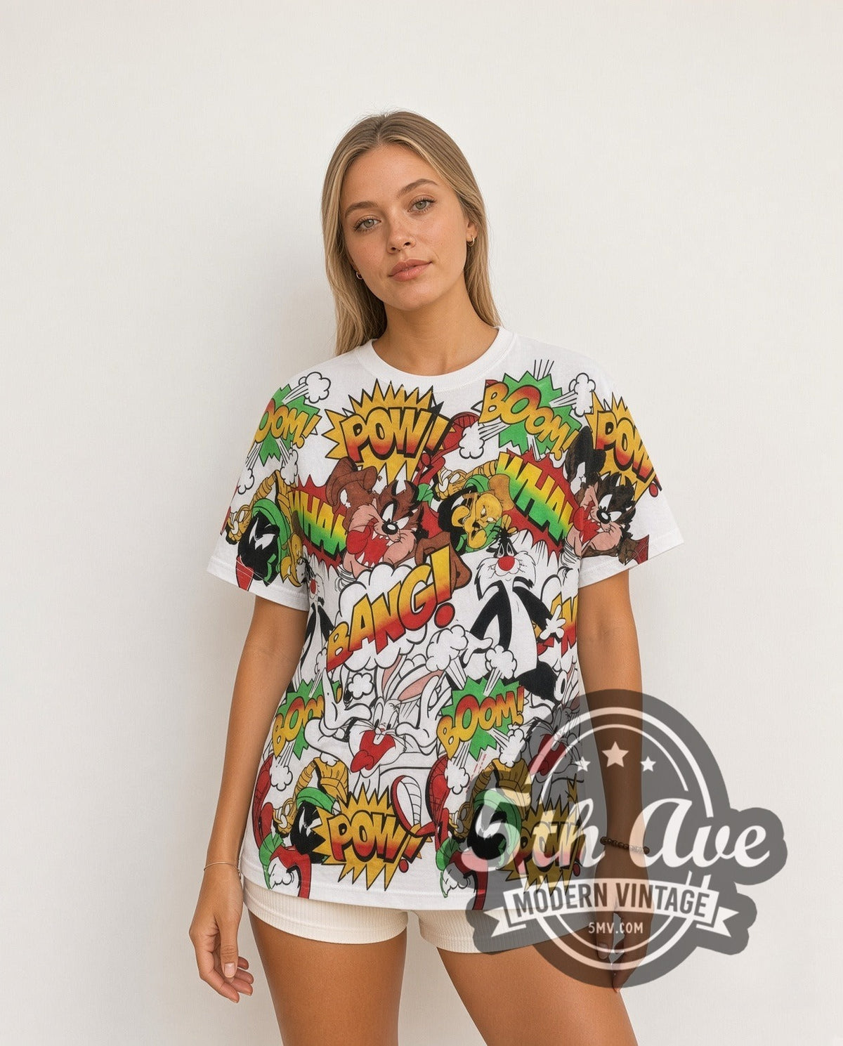 Model wearing the Looney Tunes Comic POW BANG Action Collage all-over-print vintage cartoon t-shirt in white