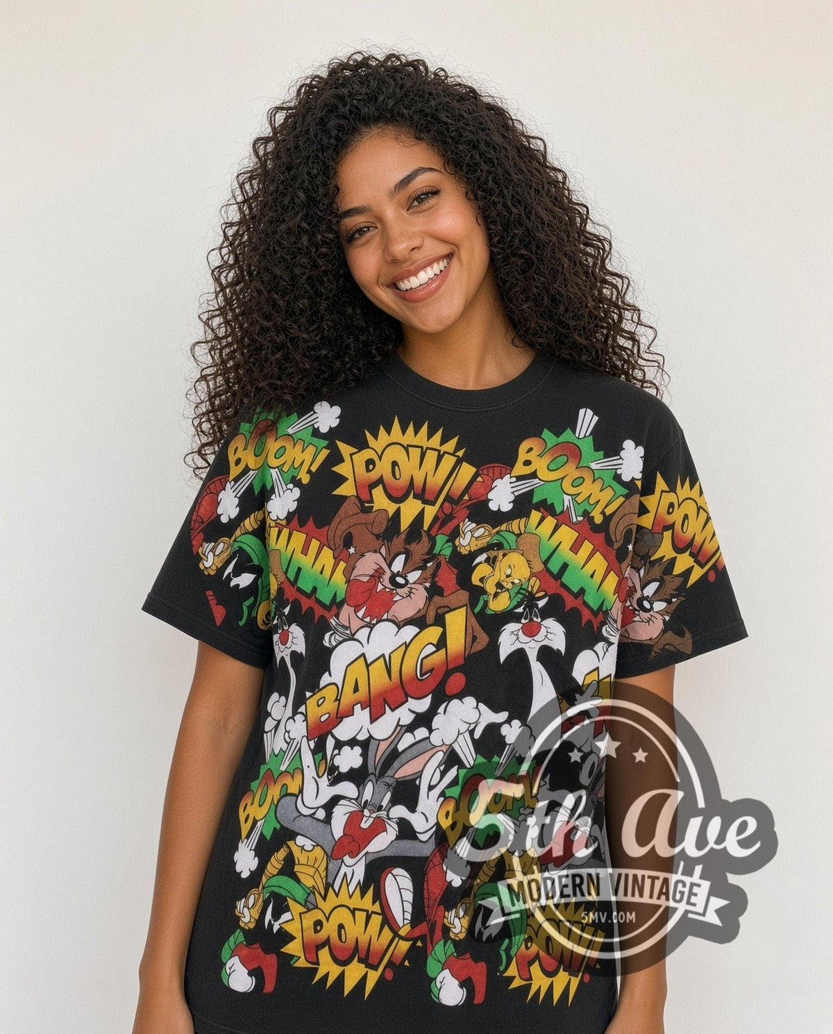 Model wearing the Looney Tunes Comic POW BANG Action Collage all-over-print vintage cartoon t-shirt in black