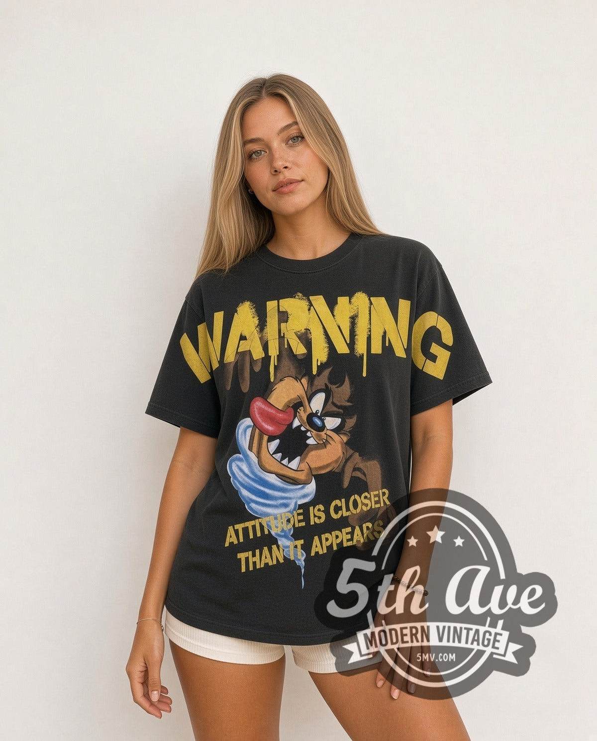 Model wearing the Looney Tunes Taz Warning Attitude Is Closer all-over-print vintage cartoon t-shirt in black