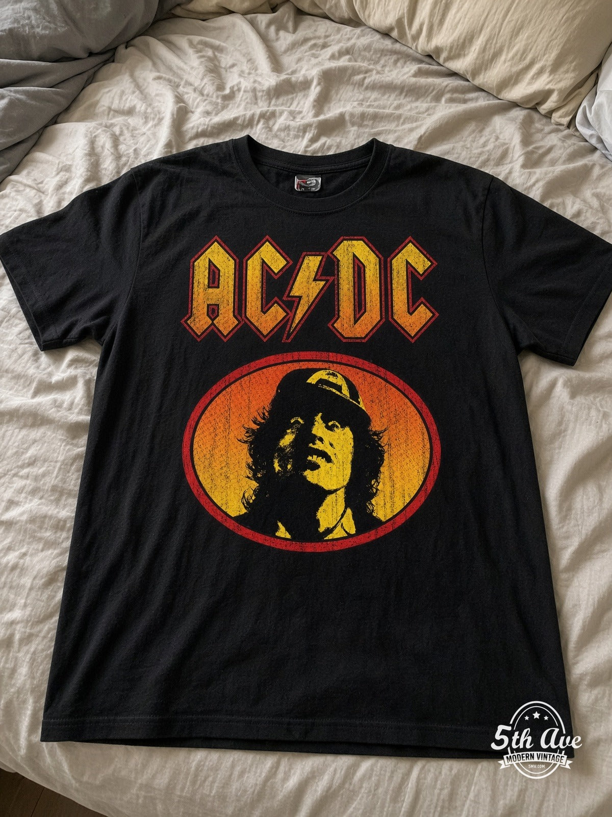 AC/DC Angus Young oval vintage t-shirt laid on bed