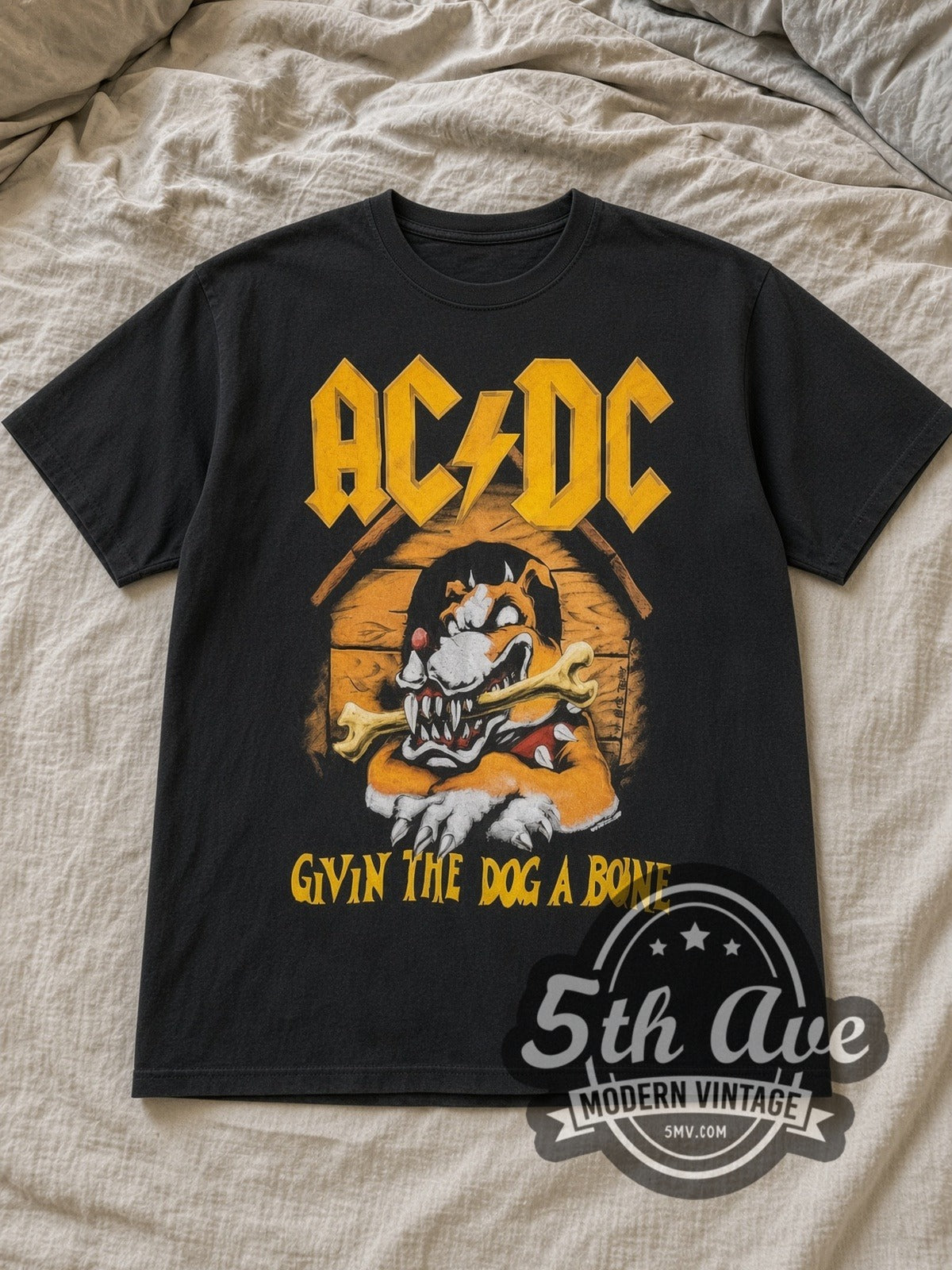 Black AC/DC Givin the Dog a Bone World Tour 1993 Vintage Band T-Shirt laid flat on a linen bed