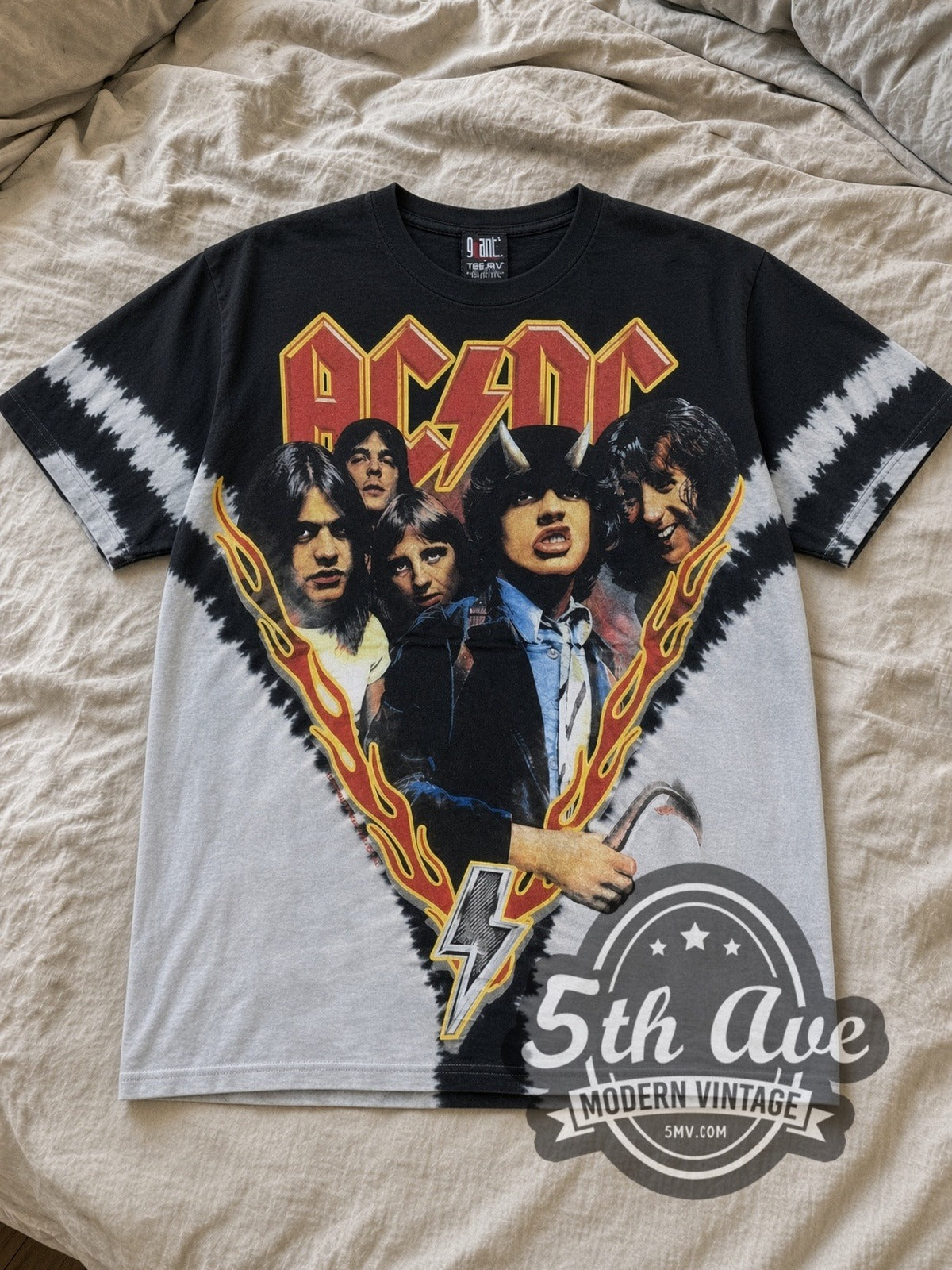 Black and grey tie-dye AC/DC Highway to Hell Flame V Black Grey Tie Dye Vintage Band T-Shirt laid flat on a linen bed