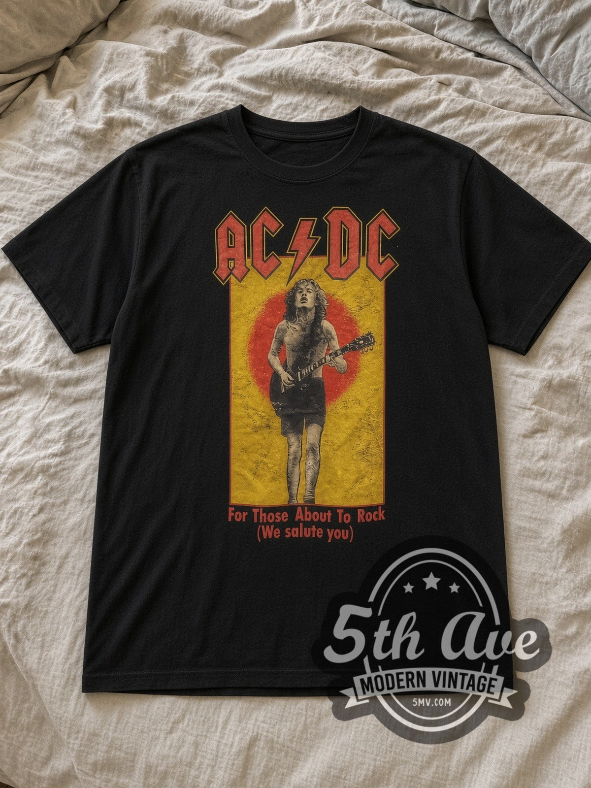 Black AC/DC For Those About to Rock Angus Vintage Band T-Shirt laid flat on a linen bed