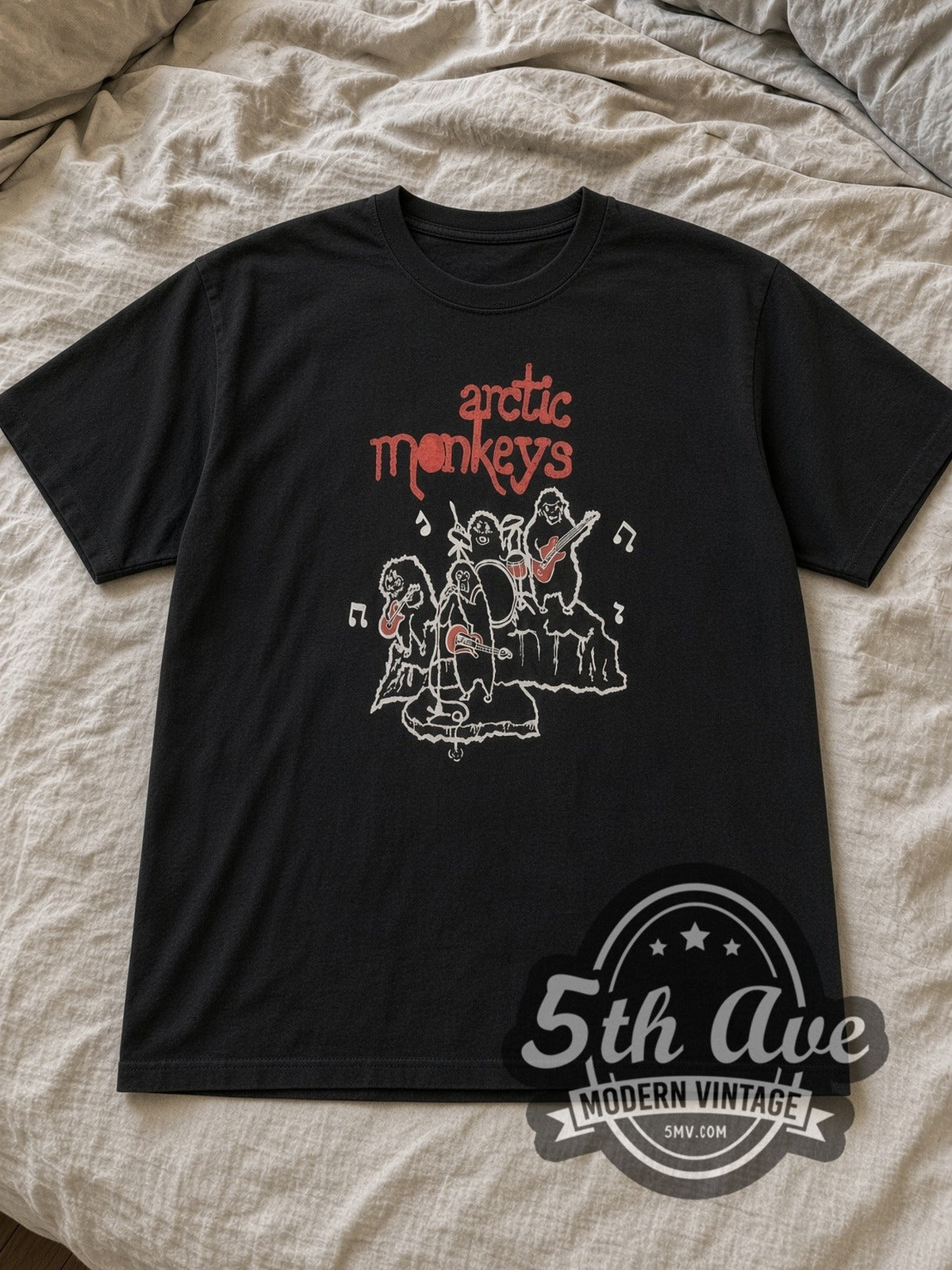Black Arctic Monkeys Vintage Band T-Shirt laid flat on a linen bed