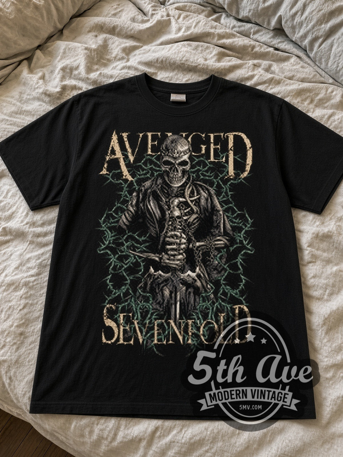 Avenged Sevenfold Skeleton in Barbed Wire black graphic tee laid flat on linen bed