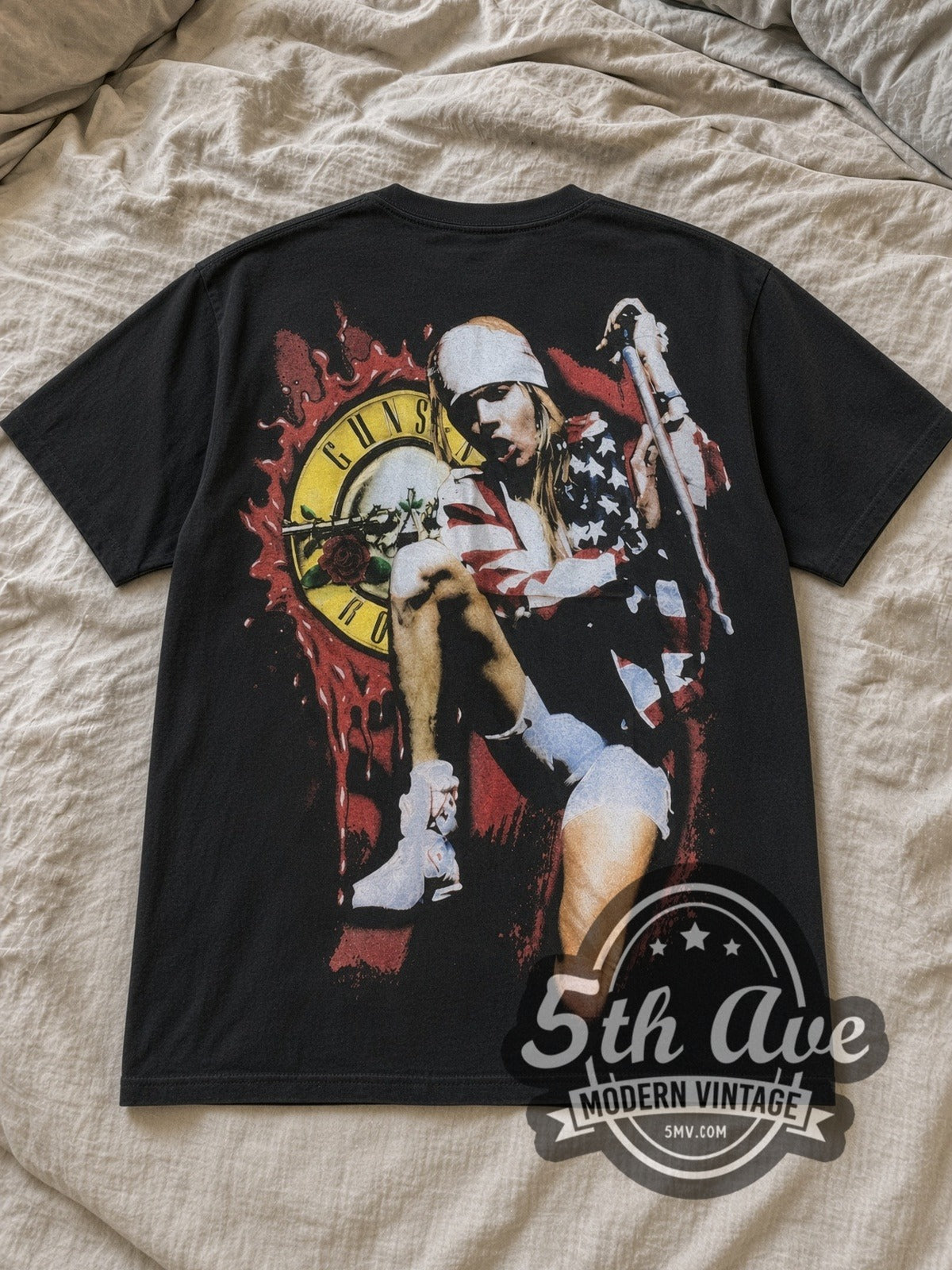 Black Guns N' Roses Axl Rose American Flag Splatter Logo Vintage Band T-Shirt laid flat on a linen bed