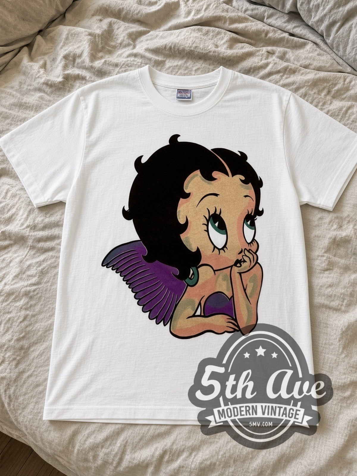 Betty Boop Angel Wings cartoon tee in white laid flat on a bed, front artwork