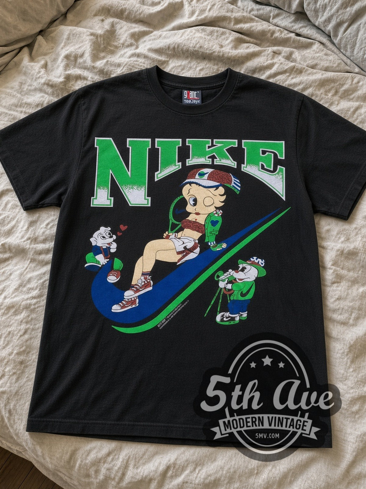 Betty Boop Nike Swoosh cartoon tee in black laid flat on a bed, front artwork